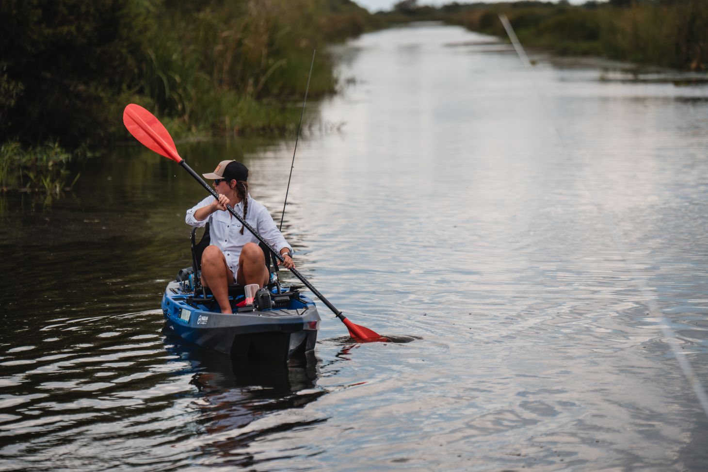 A woman paddles a kayak in a canal in Louisiana.