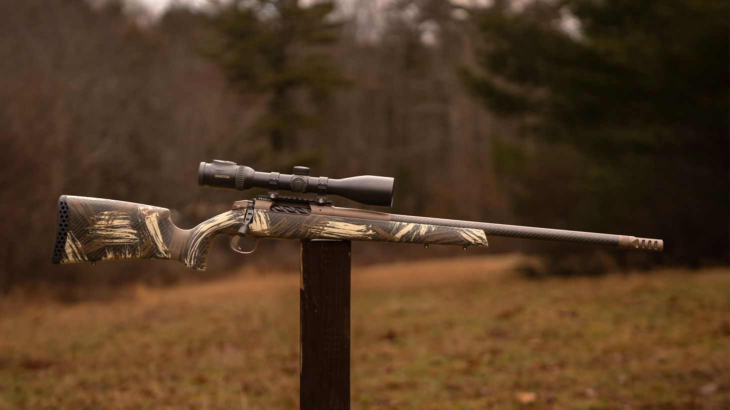 The new Weatherby Model 307 Alpine CT bolt-action rifle balanced on a post in a field. 