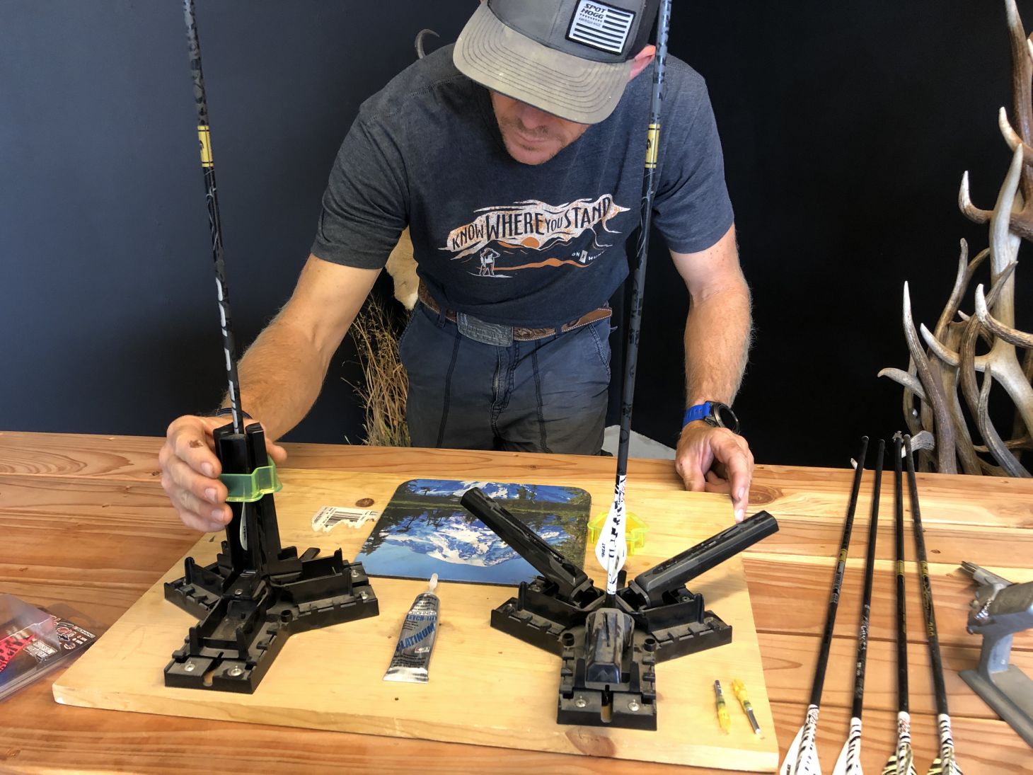 A person fletches arrows at a table. 