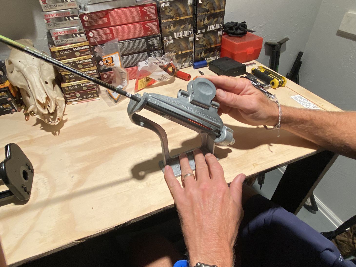 A person fletches a hunting arrow with a jig.