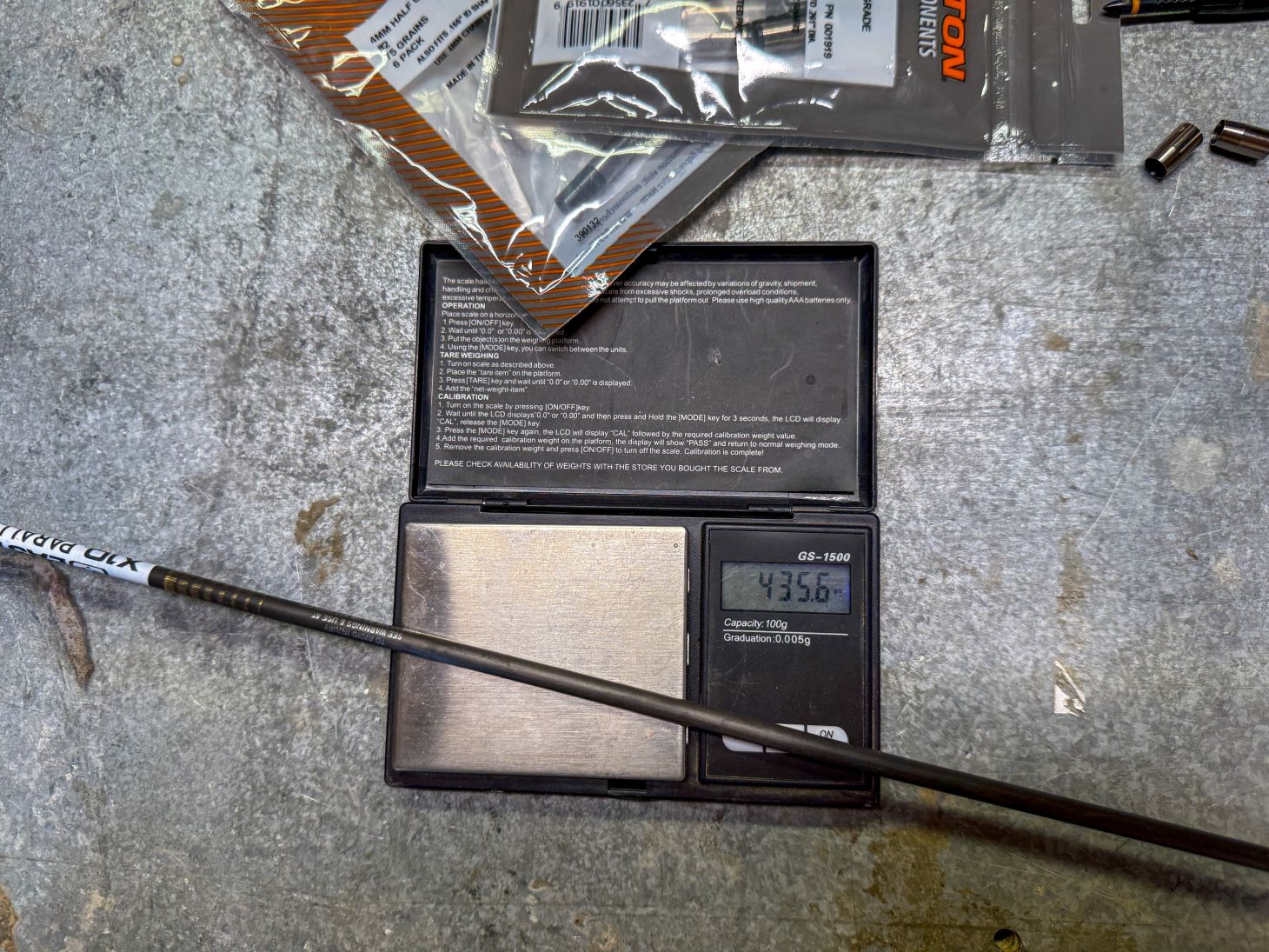 An archery arrow on a weight scale showing 435.6 grains.