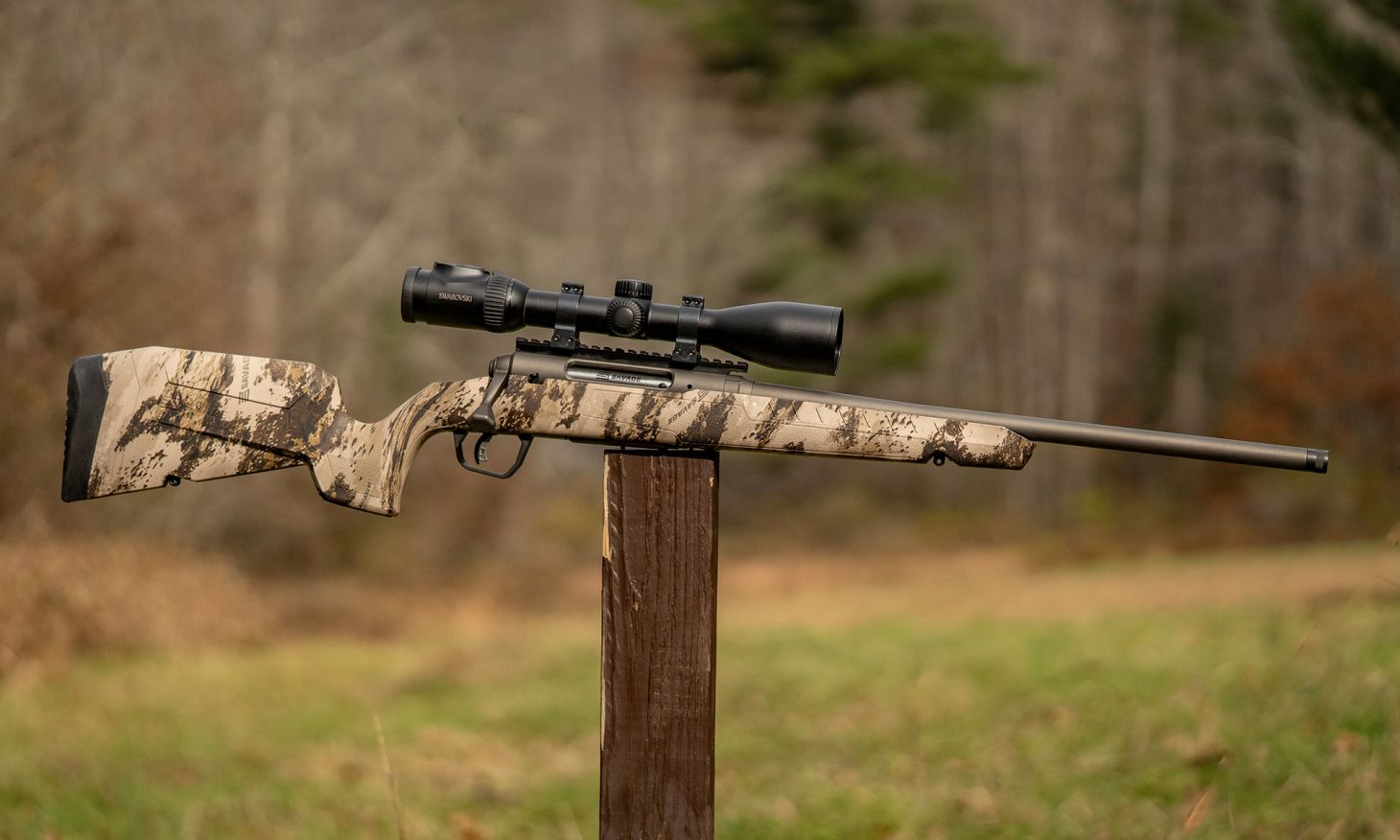 The new Savage Axis 2 Pro bolt-action rifle balance on a post with woods in background. 