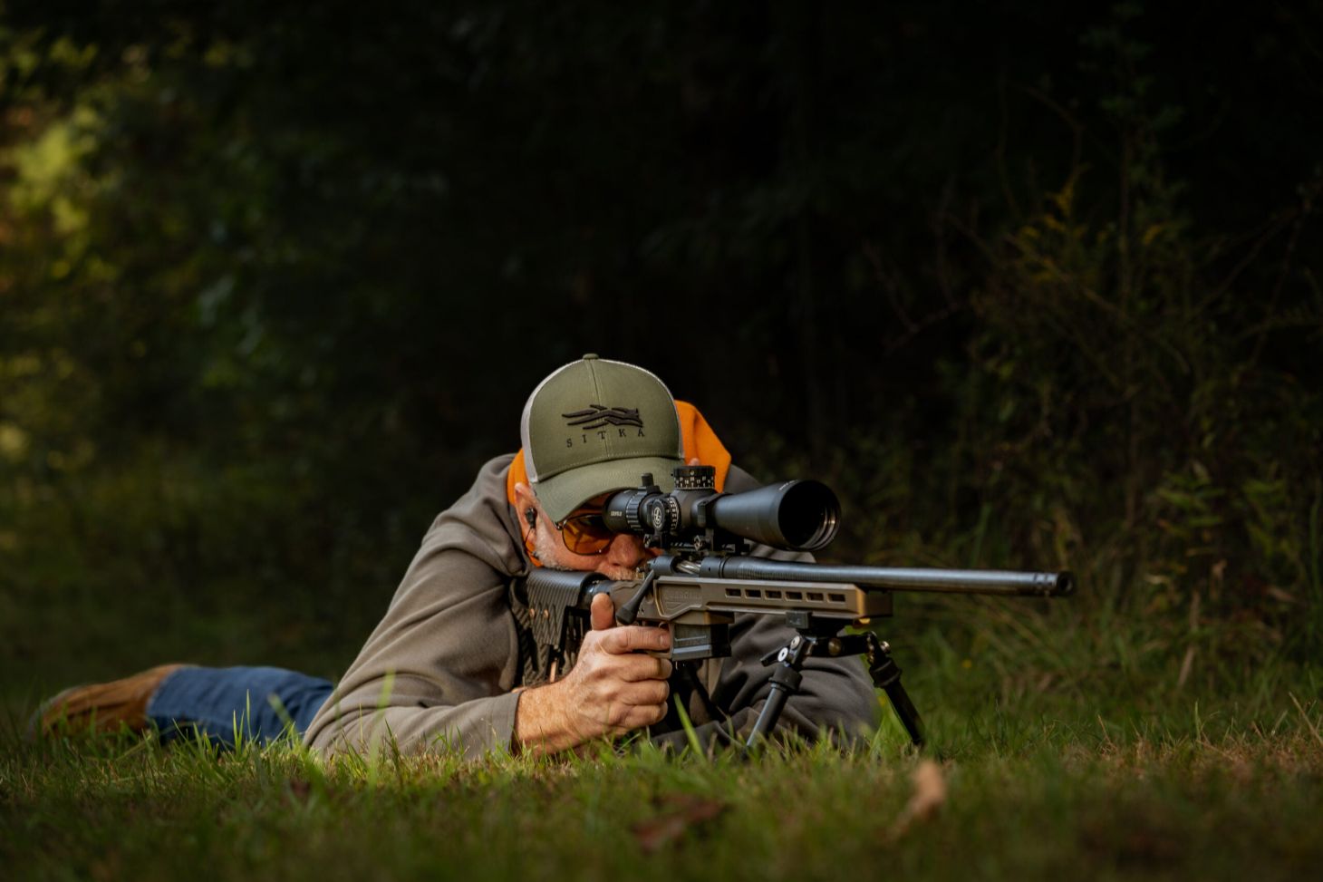 Man in the prone position shooting a rifle.