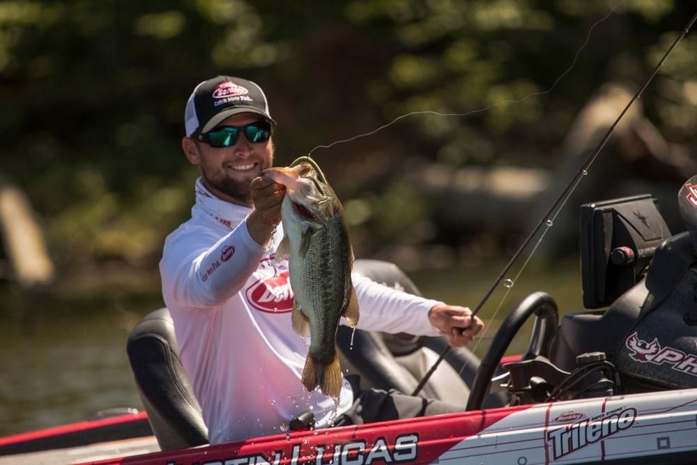 Angler holding up largemouth bass in boat