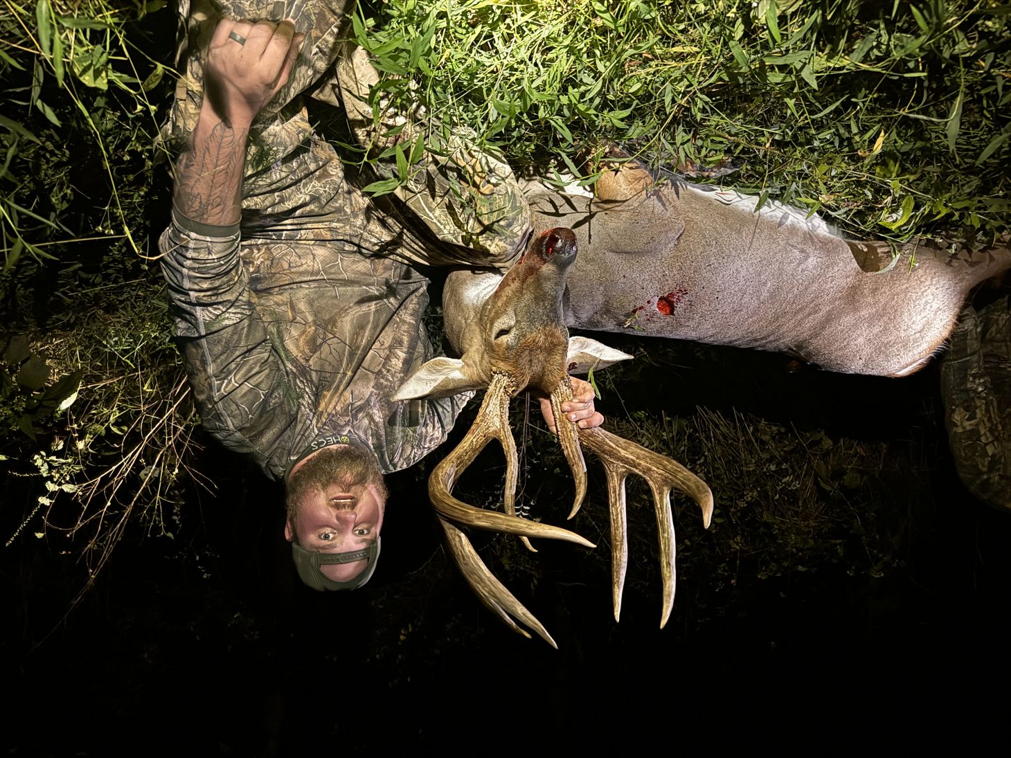 Kentucky hunter Brandon Burman postes at night with a big 8-point whitetail buck. 