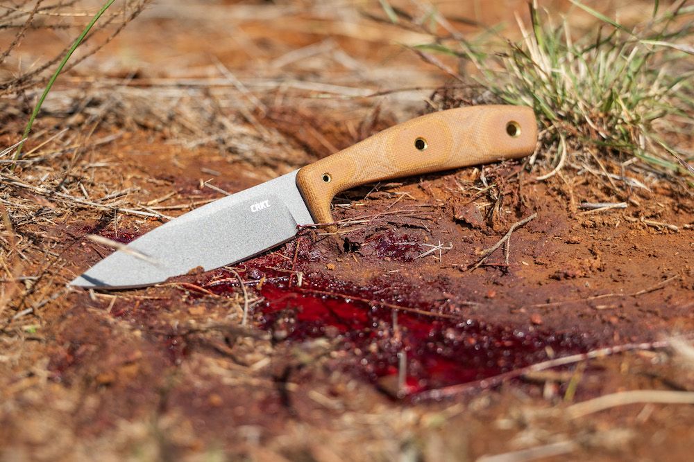 CRKT Soldotna knife on ground with deer blood