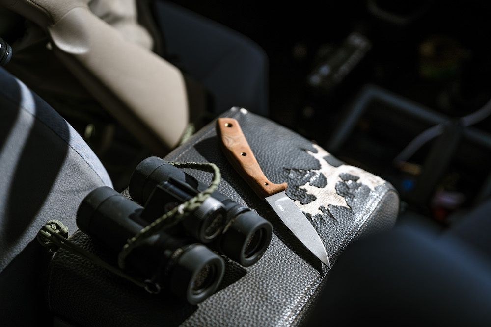 CRKT Soldotna Knife in jeep next to binoculars