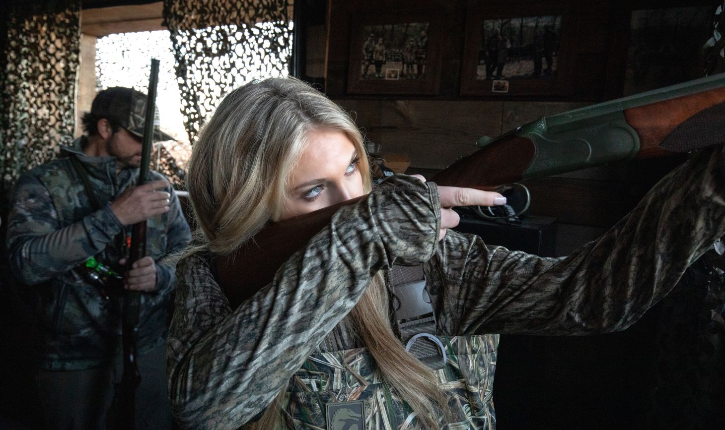 A waterfowl hunter shoots a CZ Redhead All-Terrain over-under shotgun from a duck blind.
