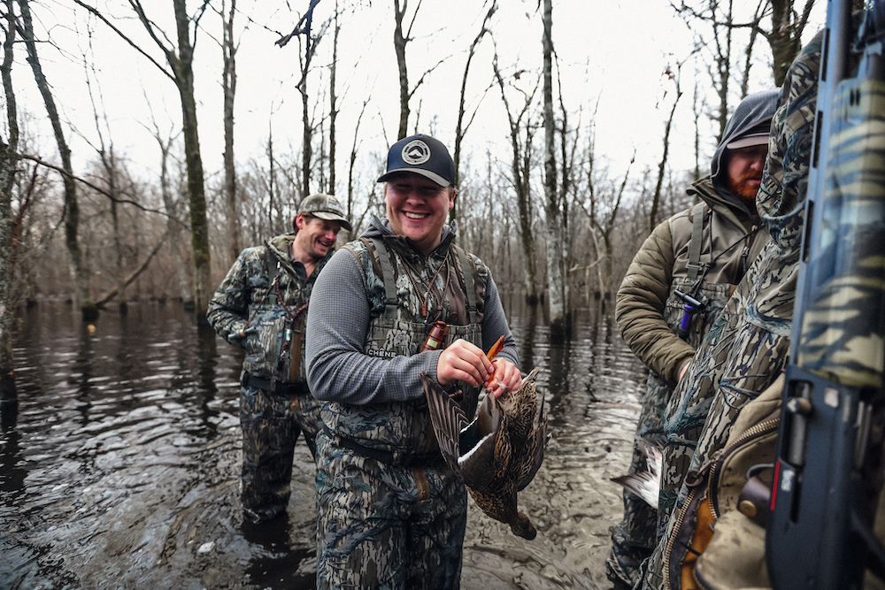 Duck hunters wearing Chene Gear waders holding ducks