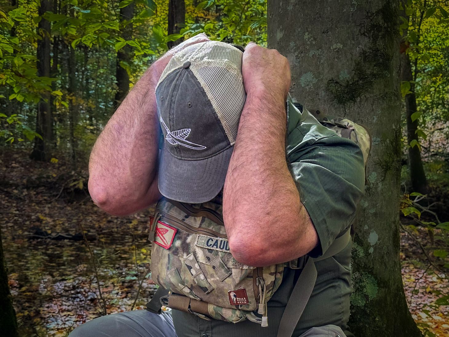 A hiker demonstrates how to protect his neck and face during a lion attack