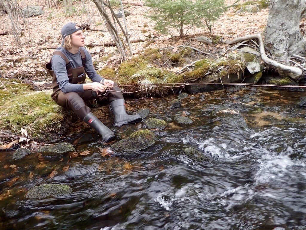 A man fishing a small stream for trout