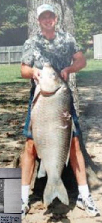 A bowfisherman poses with a world record bigmouth buffalo. 
