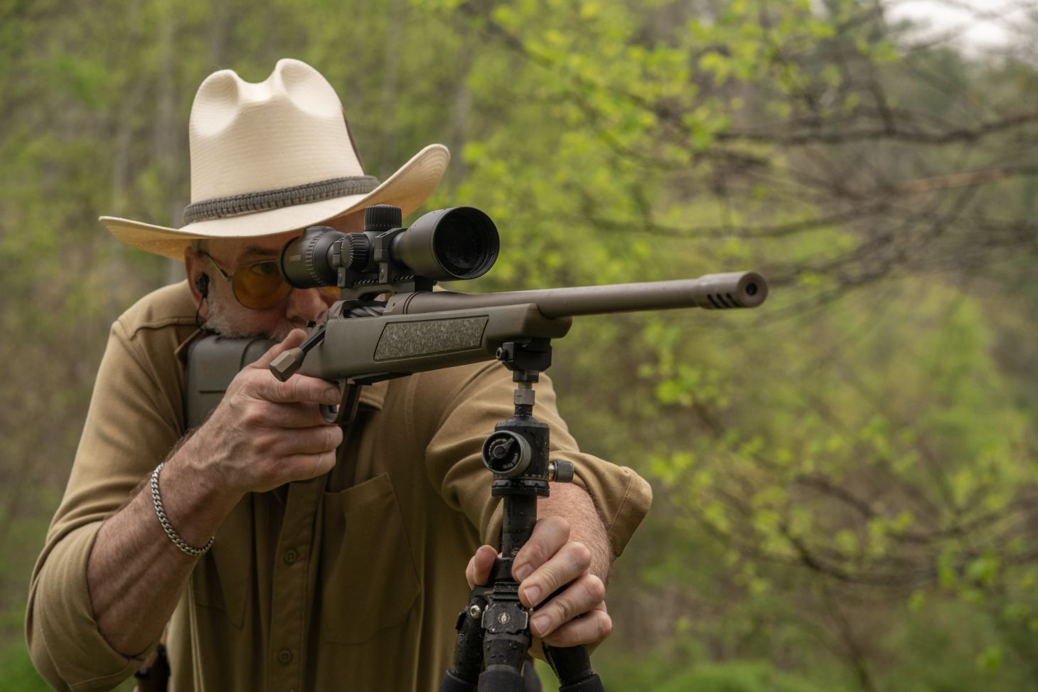 A shooter fires the new Christensen Arms Evoke rifle a tripod rest. 