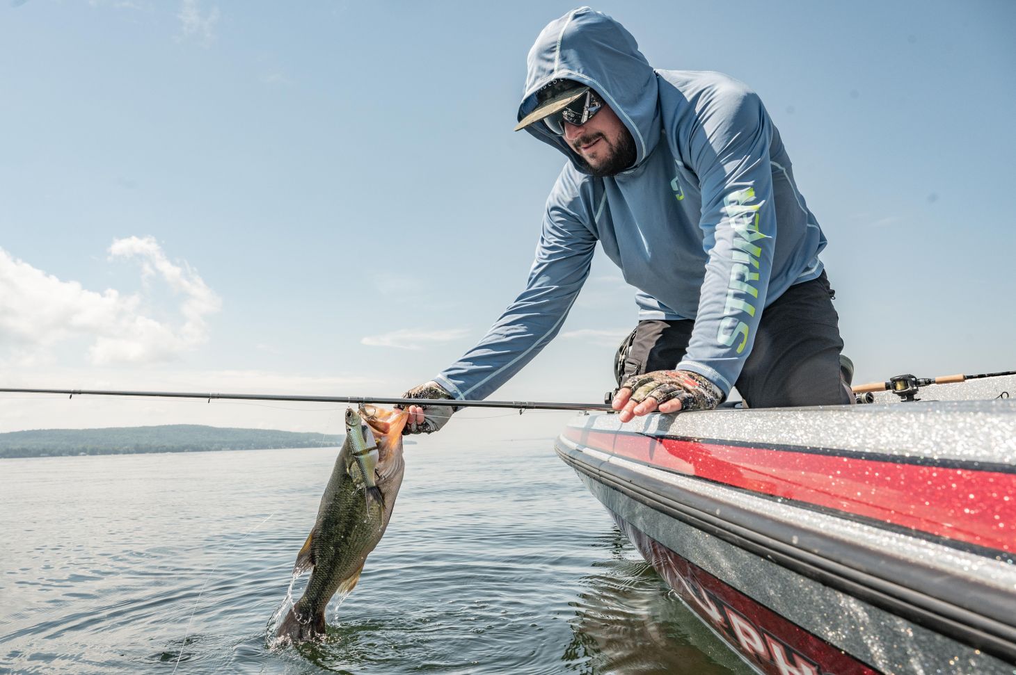 Anglers holds bass over water
