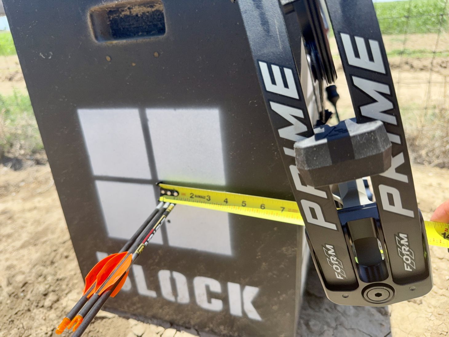A very small group of arrows shot into a target is measures using a tape measure. 