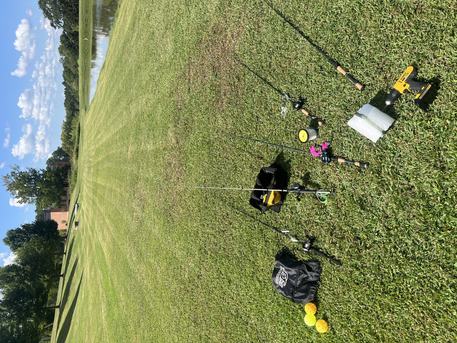 Fishing rods on a lawn next to a pond.