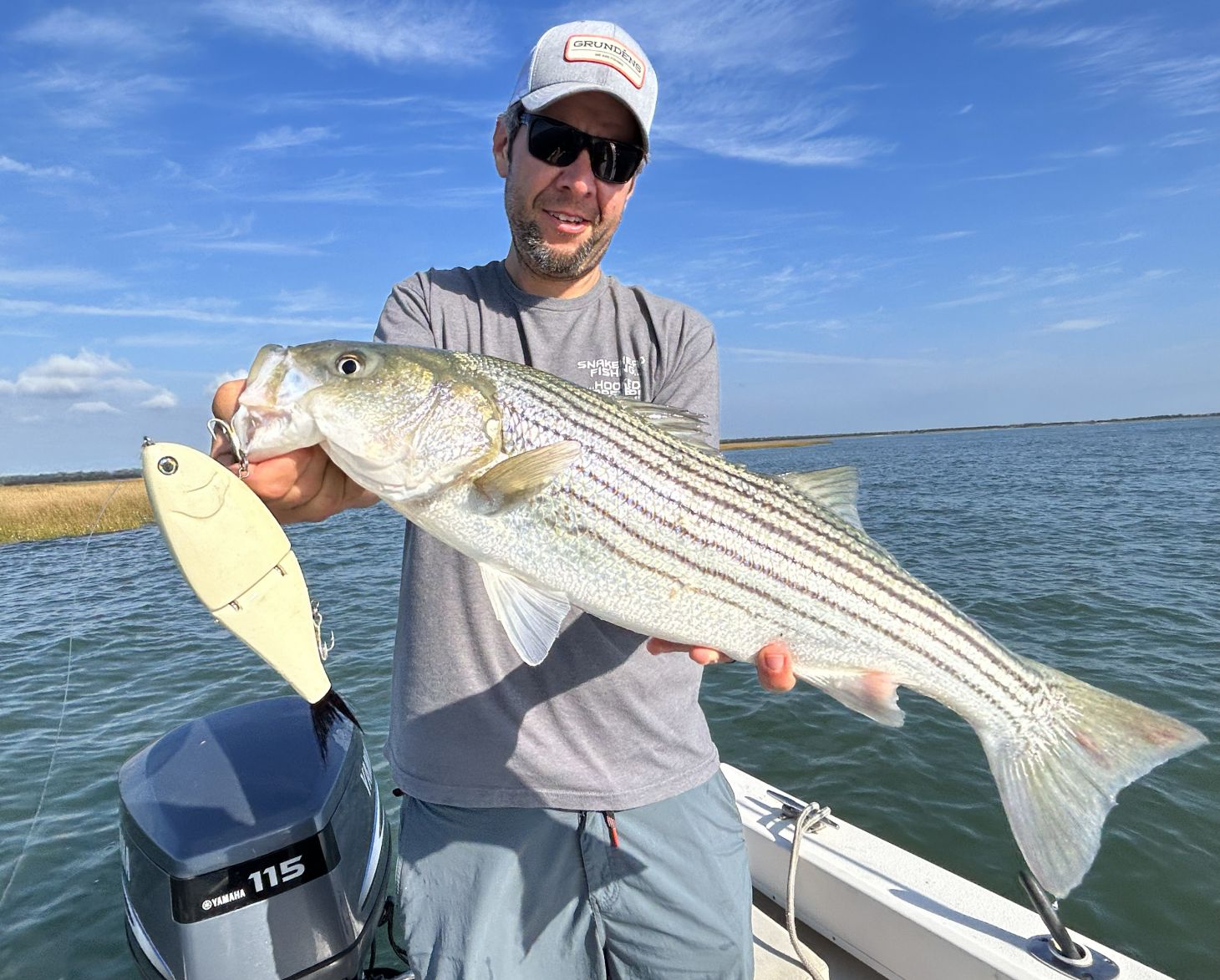 Angler holds up striped bas