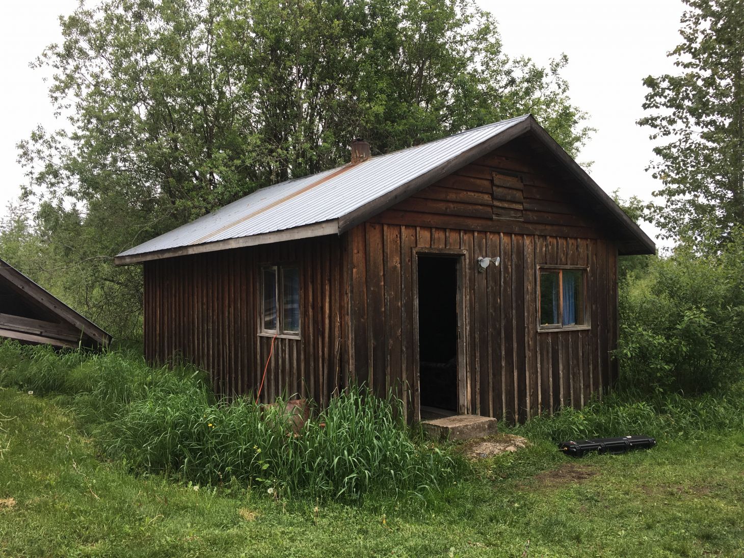 an old wooden cabin with a tin roof.