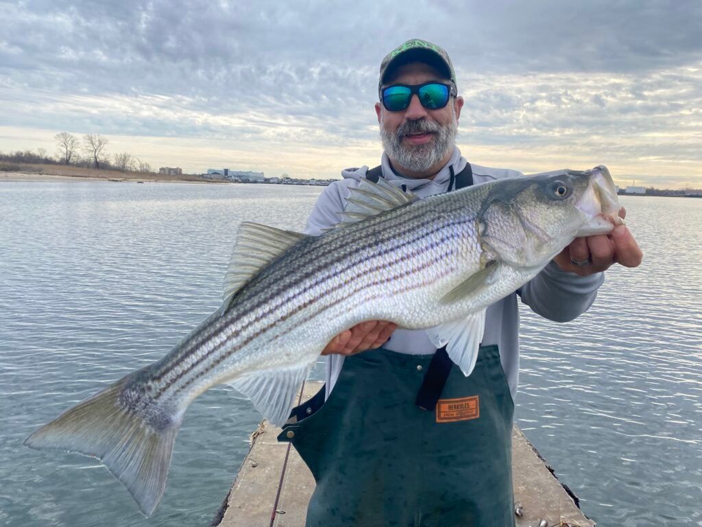 Angler wearing Grundens Herkules bibs holding fish