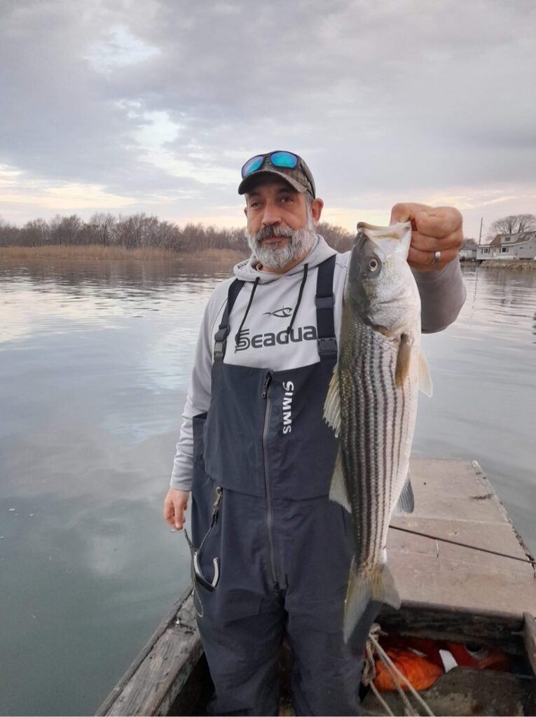Angler wearing Simms Pro Dry Bibs holding fish