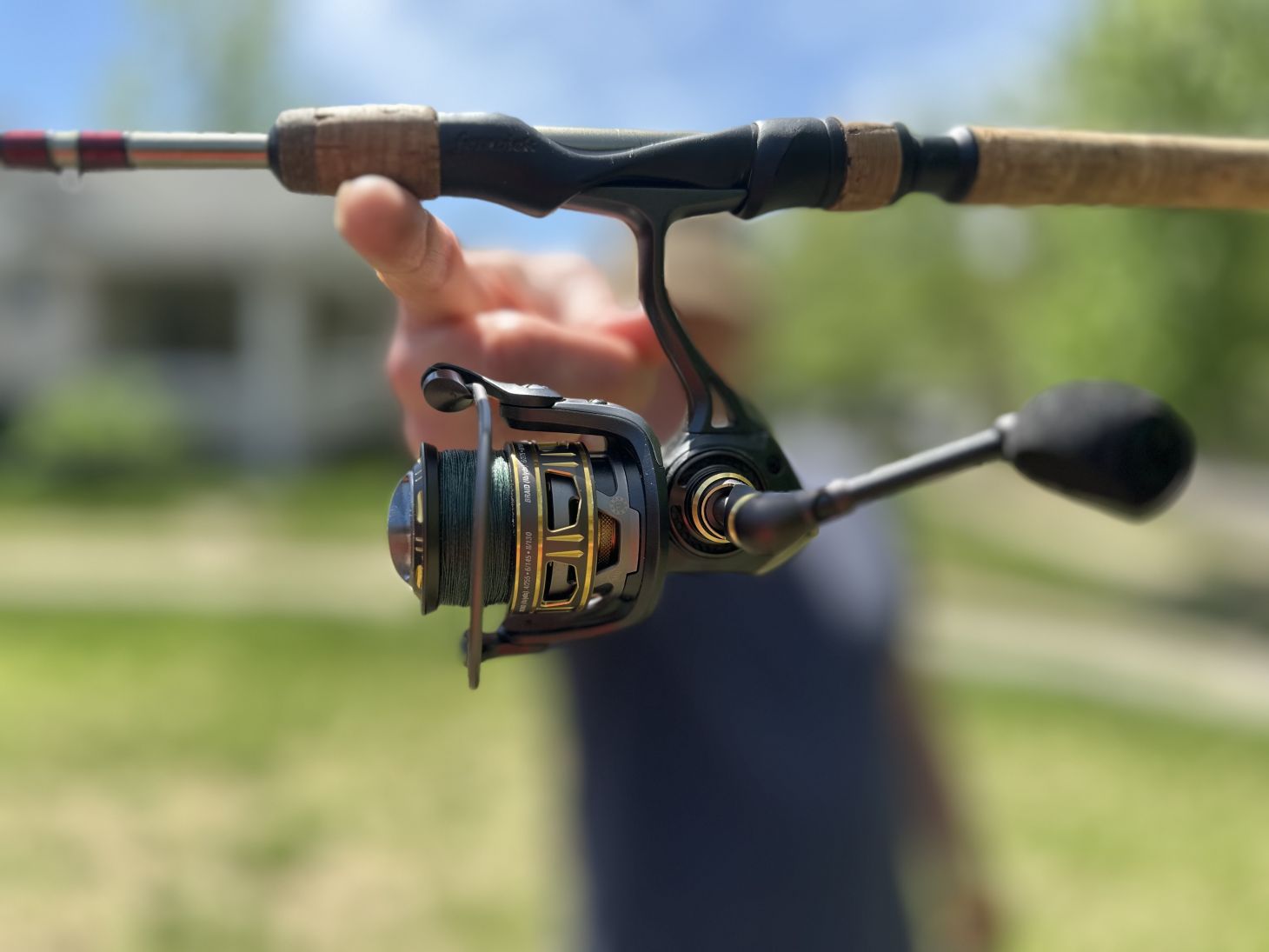 Hand holding up spinning reel