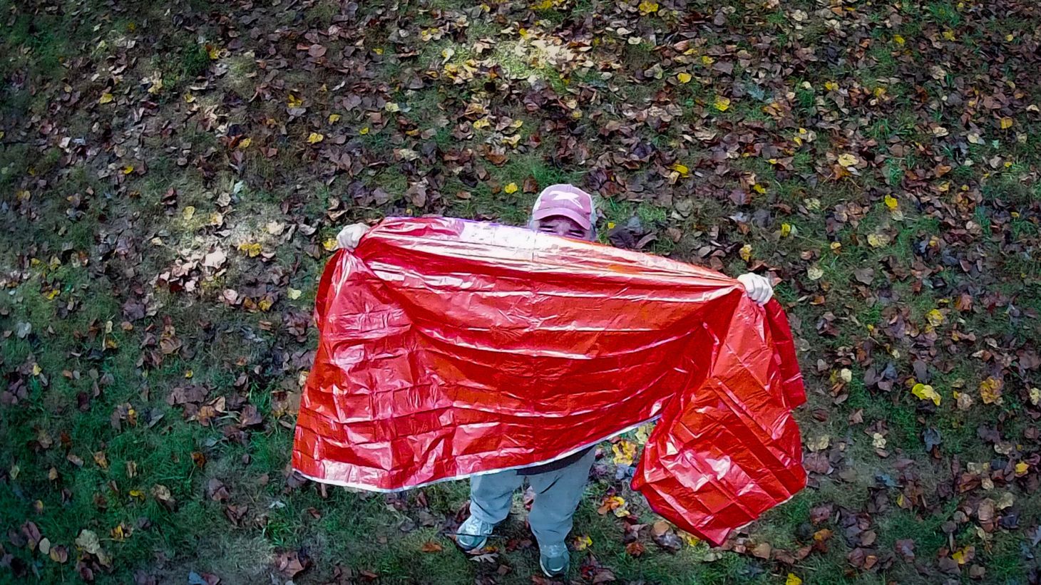 Man uses a space blanket to signal for help in the woods