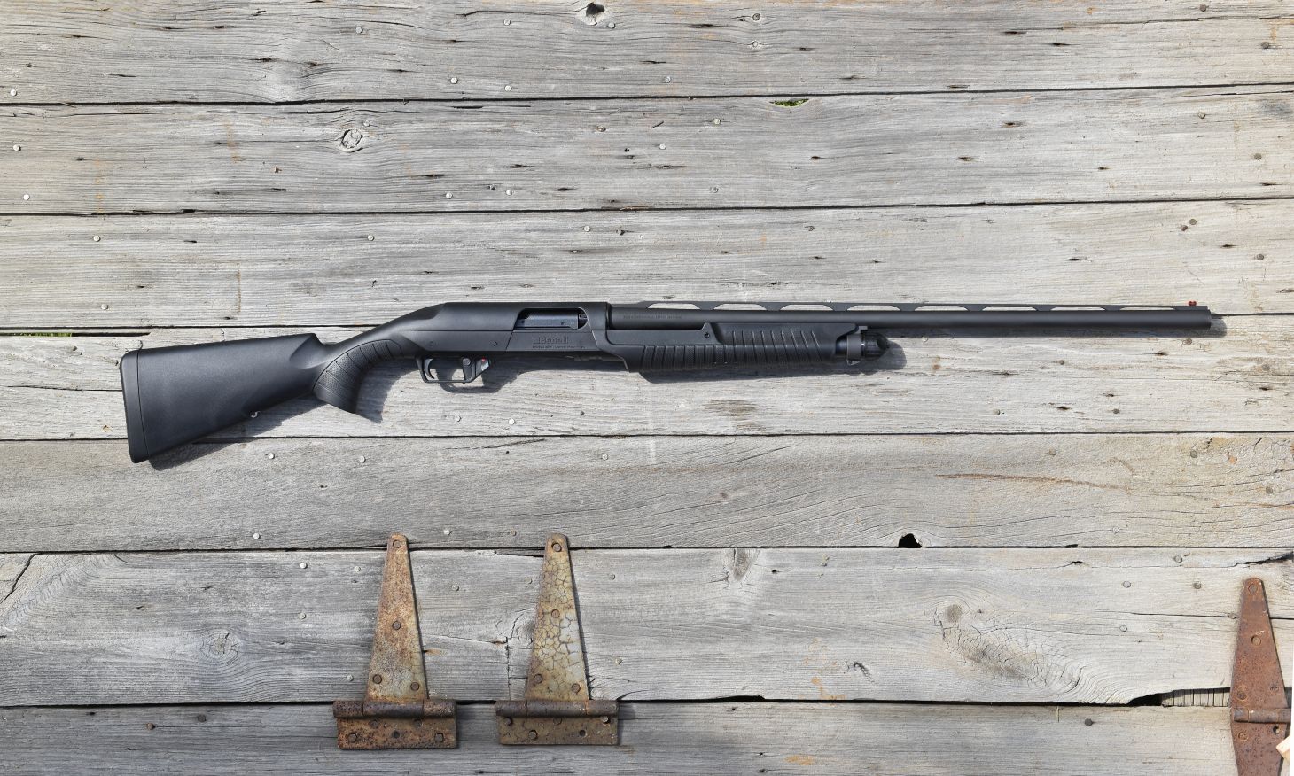 The new Benelli Nova 3 shotgun lying on barn boards. 