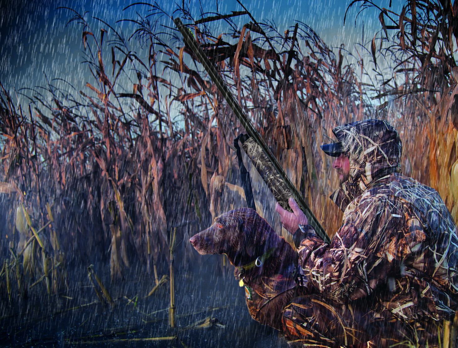 A hunter holds a Mossberg 940 Pro Waterfowl shotgun in the rain.