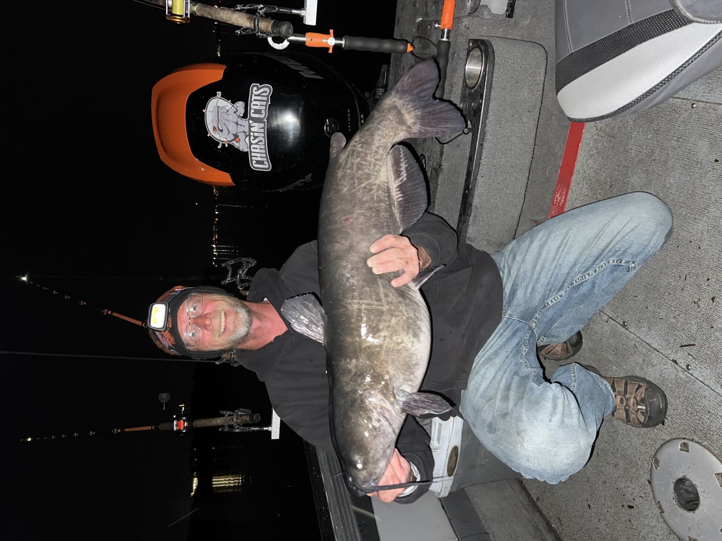 Angler holding up catfish on boat