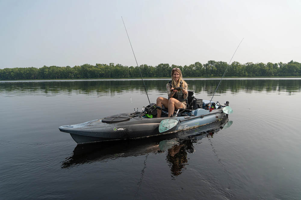 Female angler holding bass on Old Town Sportsman BigWater ePDL+ 132 Fishing Kayak
