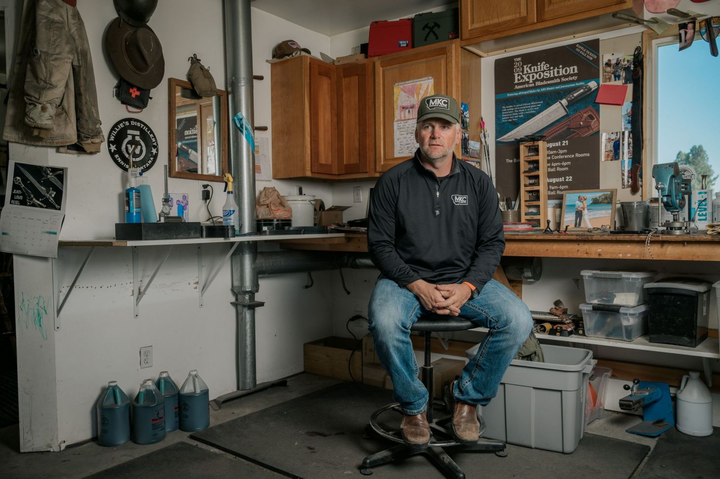 A knife maker poses for photos in his shop. 