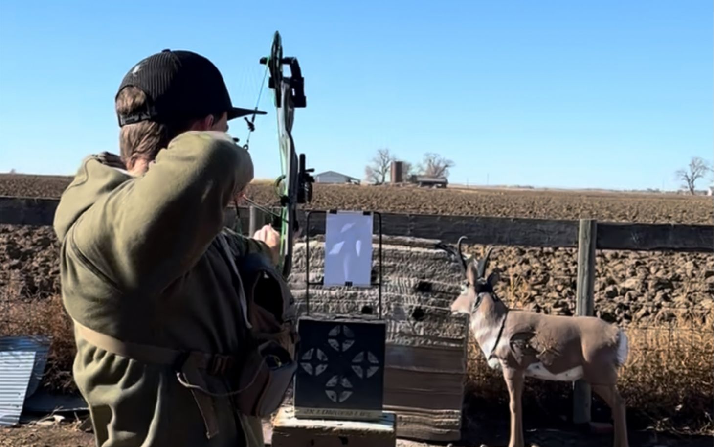 An archer shoots an arrow into a paper-tuning jig.