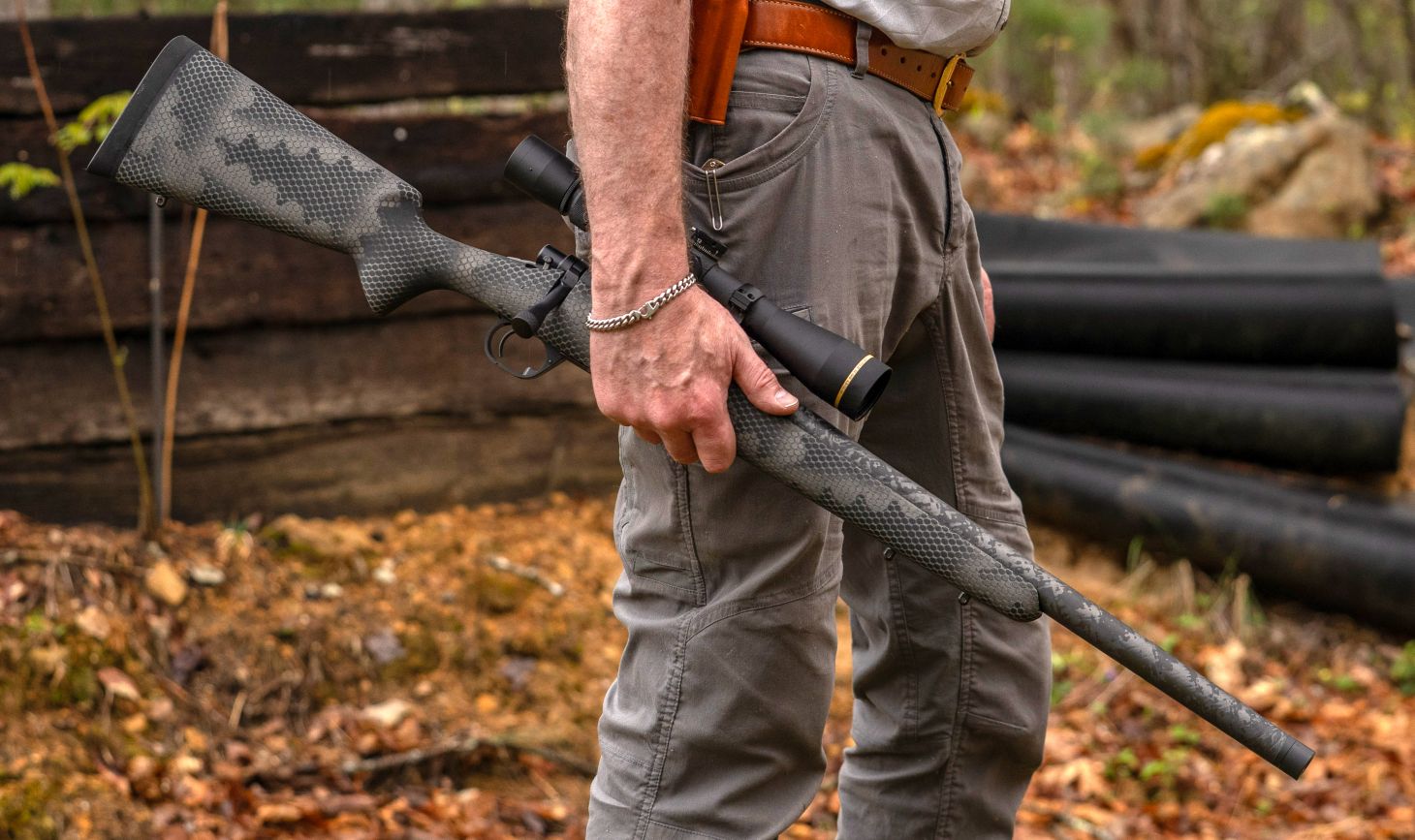 A shooter carries the Proof Research Glacier Ti bolt-action rifle in one hand by his side. 