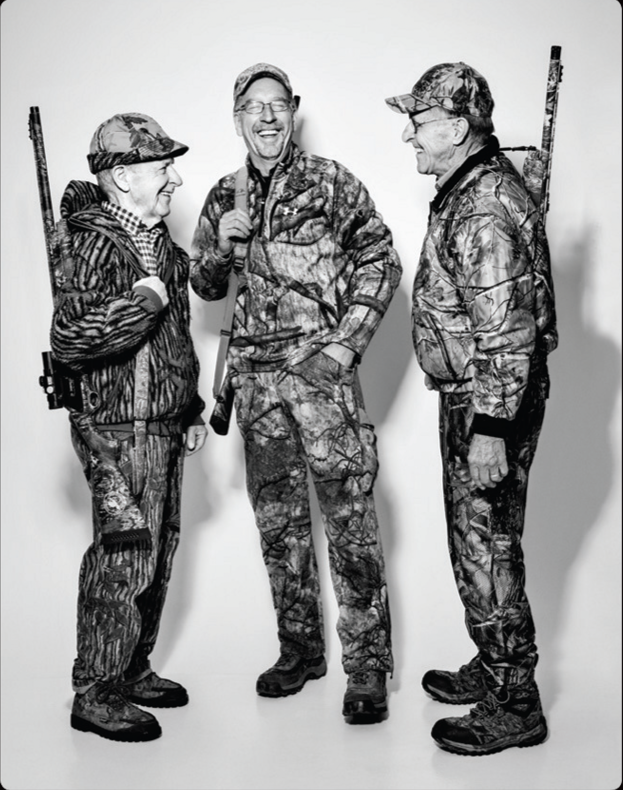 Three turkey hunters talk and laugh on a white background. 