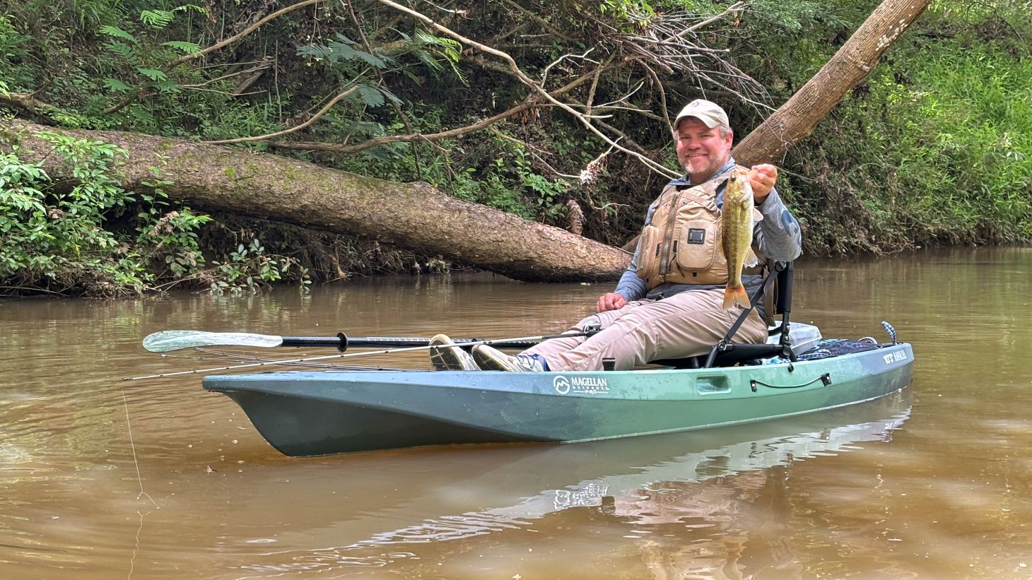 Angler holding bass on kayak