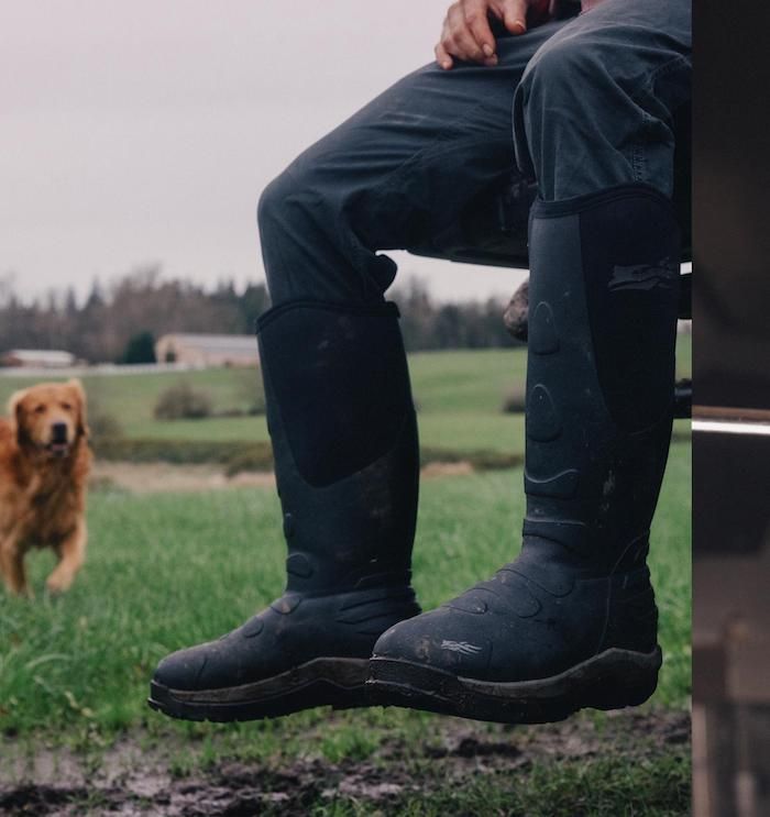 Man wearing Sitka Back40 Boots in black sitting on tailgate