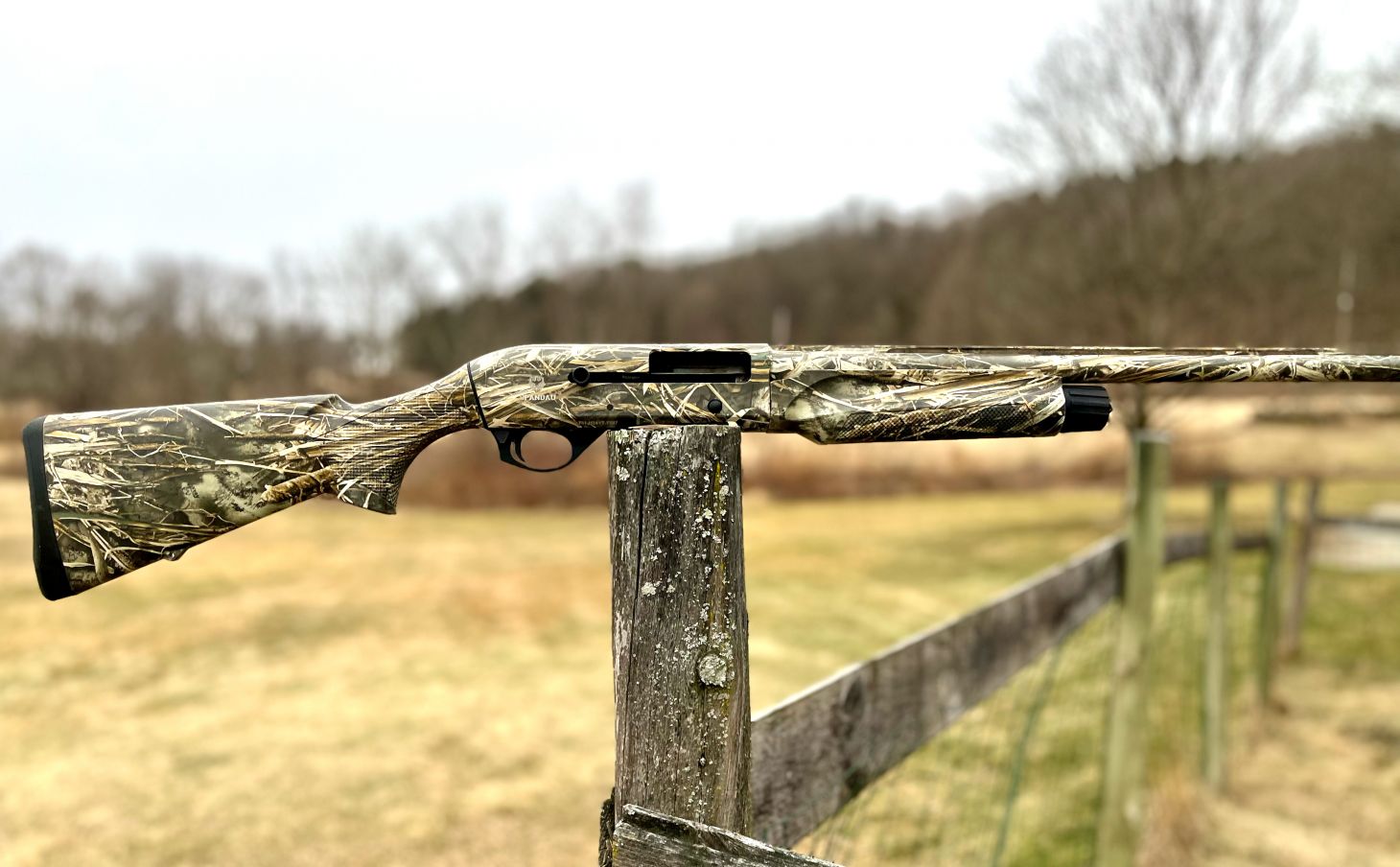 The new Spandau Arms S2 semi-auto shotgun on a post with fields in background. 