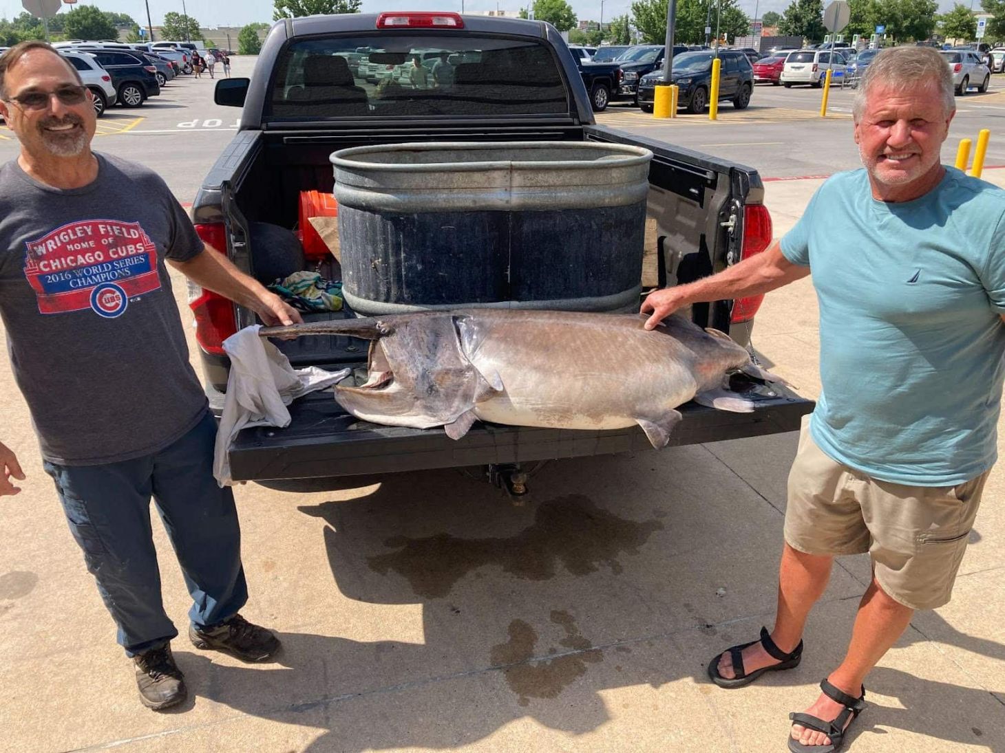 Two fishing buddies pose with a state-record paddlefish. 