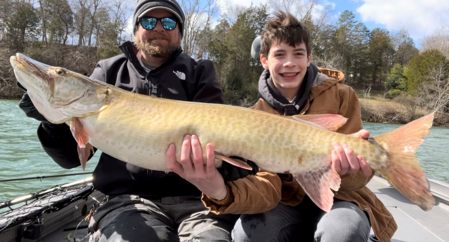 Two anglers hold up a muskie