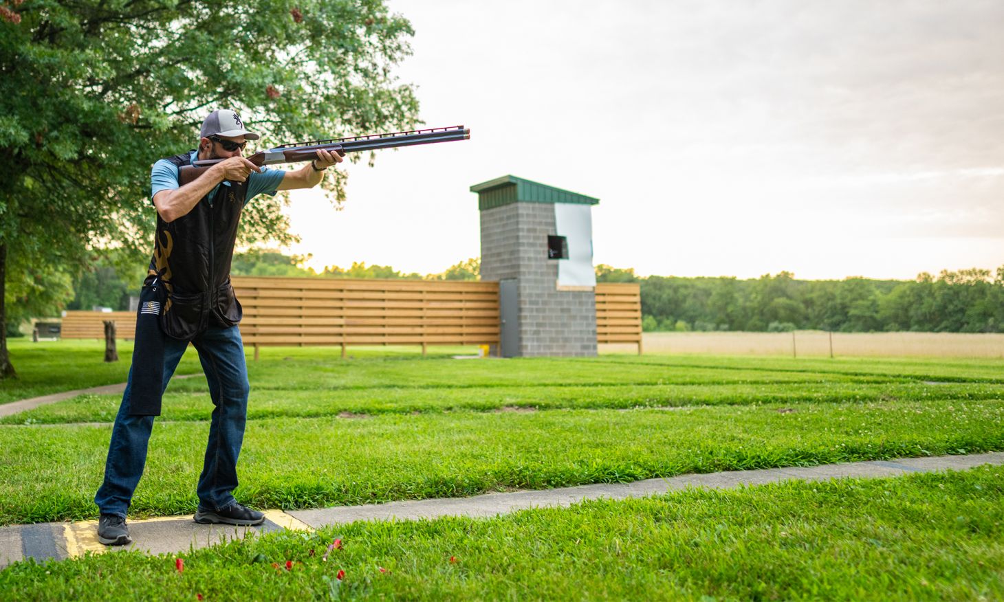 A shooter fires a Browning Citori Trap shotgun on a range.