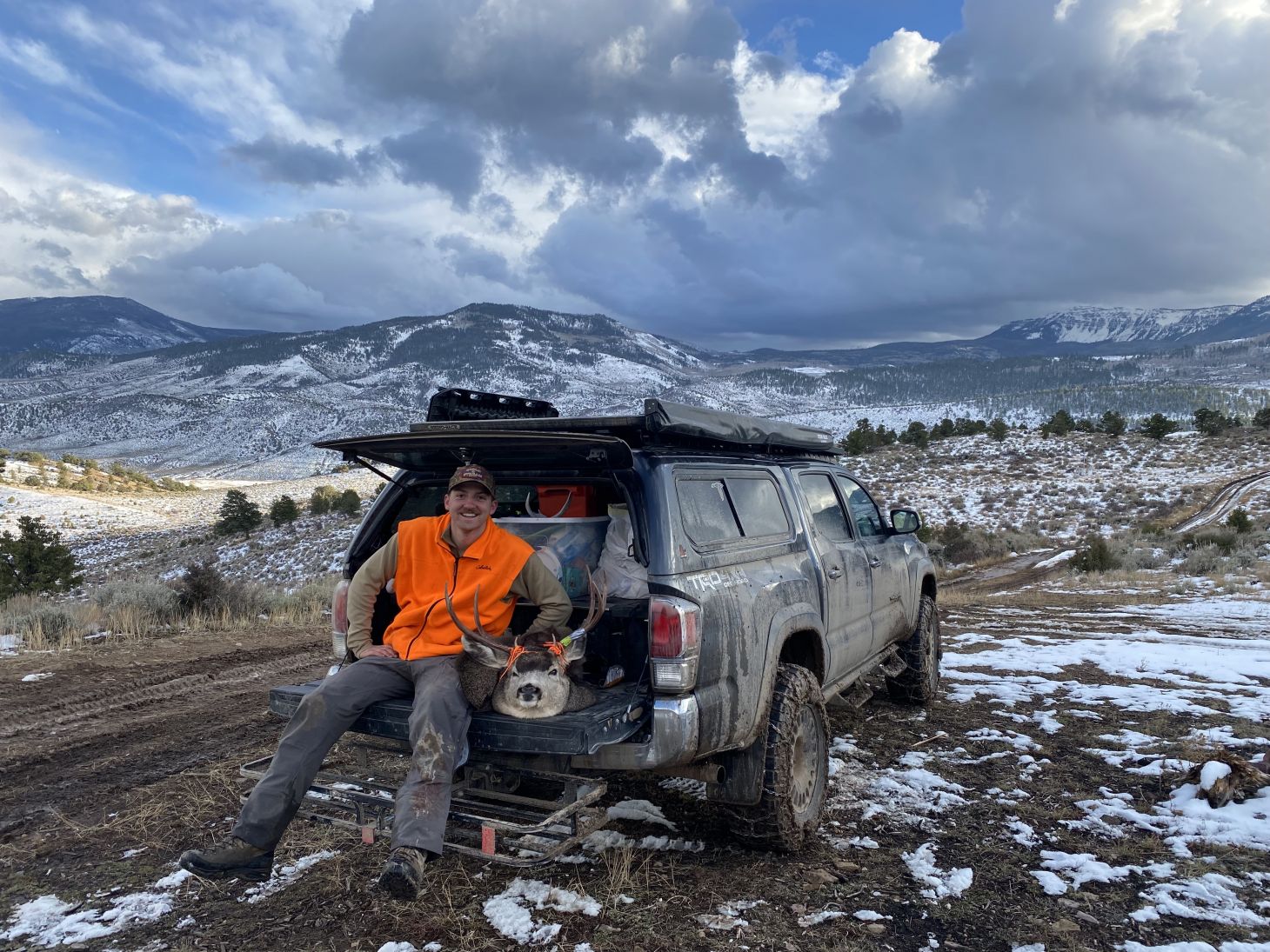 Hunter on tailgate of truck with deer