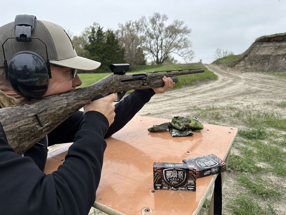 Man shooting turkey shotgun with red dot sight during optics testing