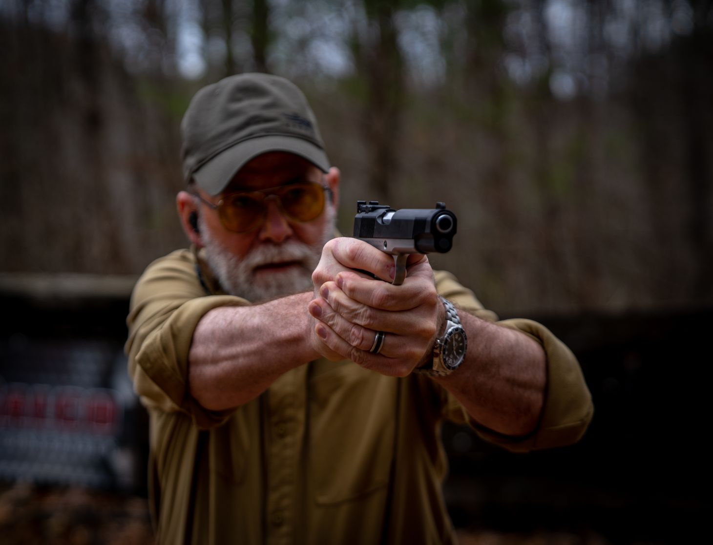 A shooter fires a handgun on the range to compare 10mm vs 45 ACP.