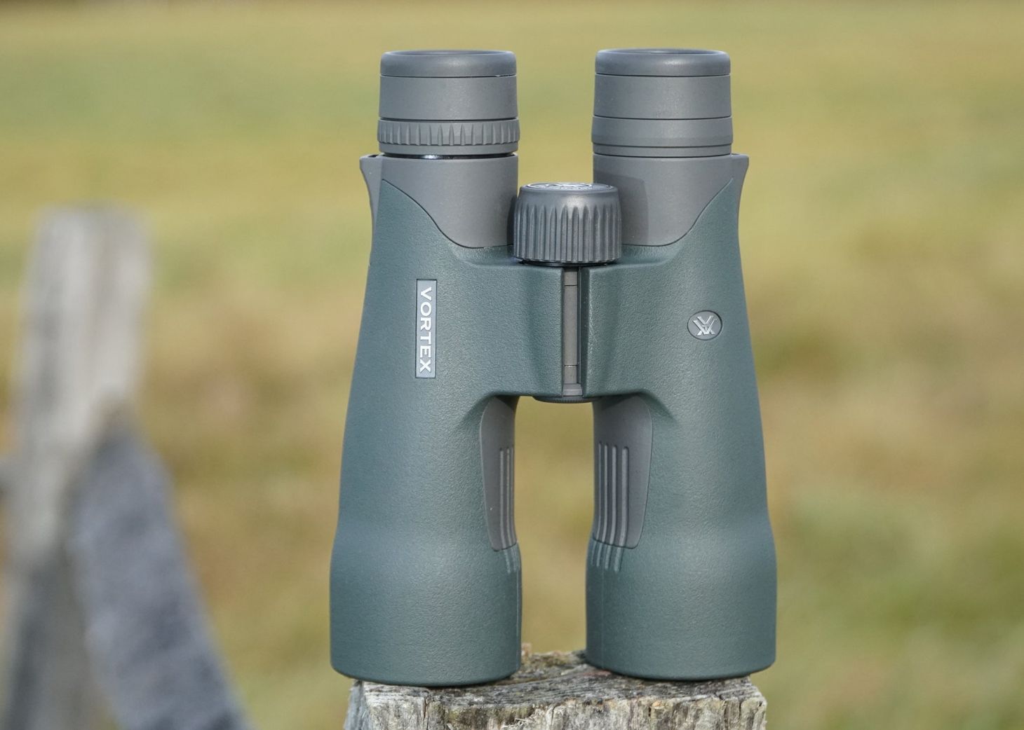 Vortex Razor UHD 10x50 binocular sitting on a fence post with field in background