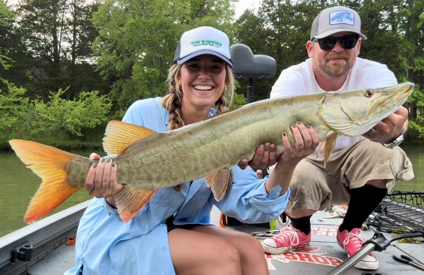 angler holds up a muskie