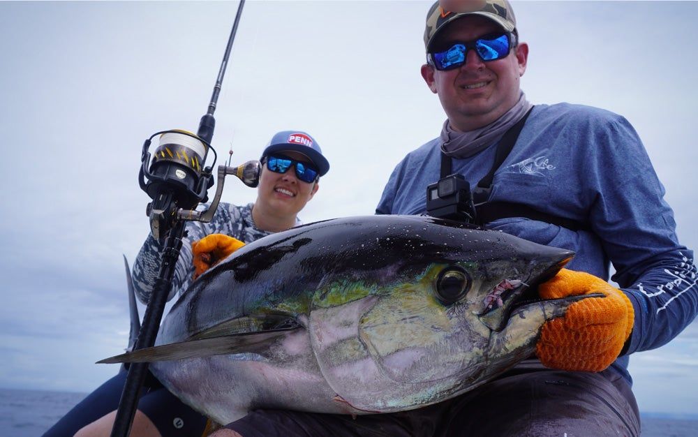 Angler holding yellowfin tuna caught with Penn Carnage III Spinning Rod